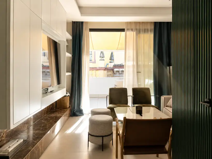 Salón con mueble de televisión a medida y peana de mármol, abierto a la terraza